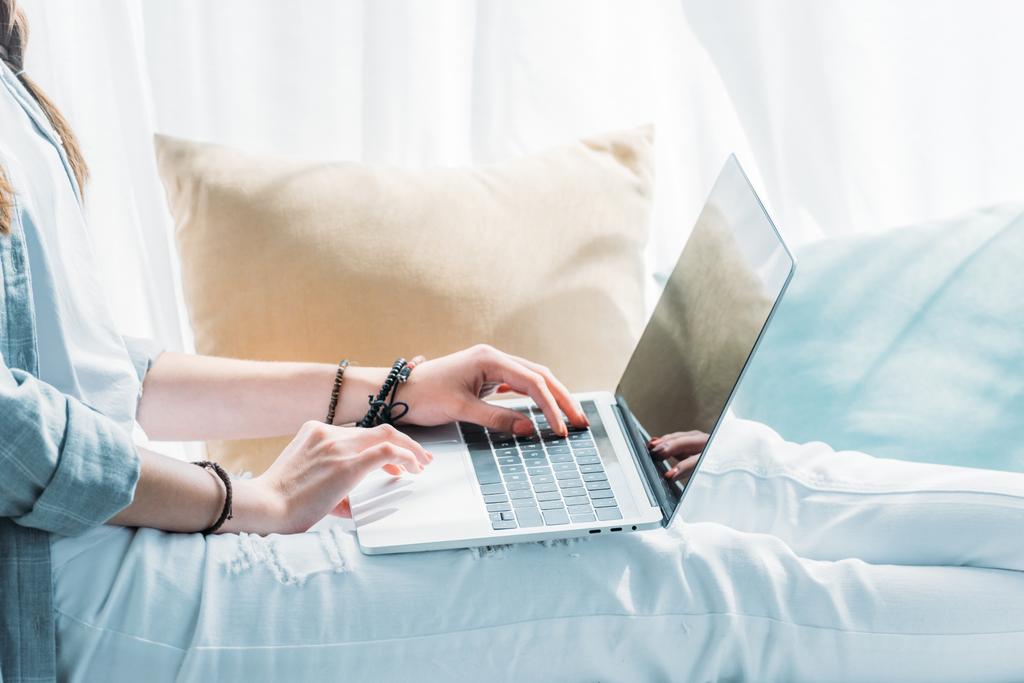 yastık ile otururken dizüstü bilgisayar kullanan kadın görünümünü kırpılmış - Fotoğraf, Görsel
