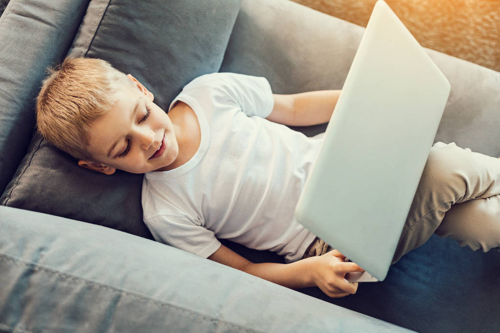 Kleiner Junge entspannt mit Laptop - Foto, Bild