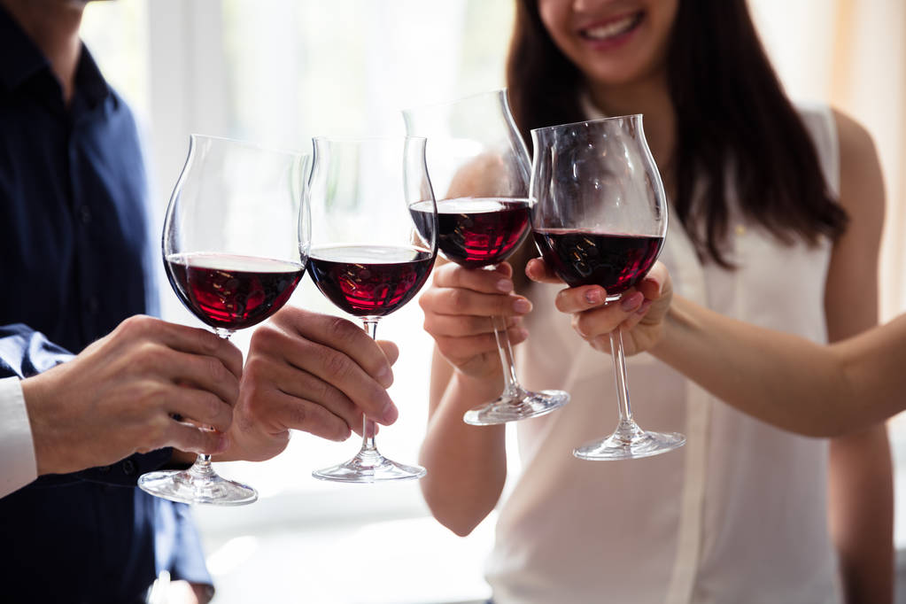 Primo piano di amici brindare bicchieri da vino alla festa - Foto, immagini