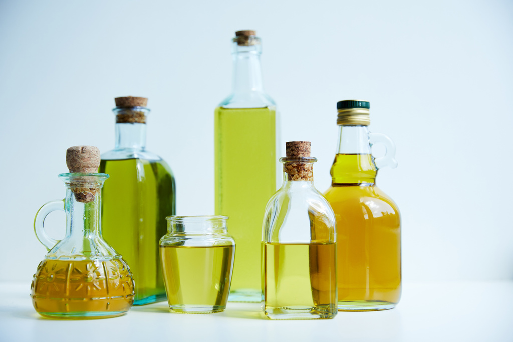 diferentes botellas de aceite de oliva aromático y frasco sobre fondo blanco
 - Foto, Imagen