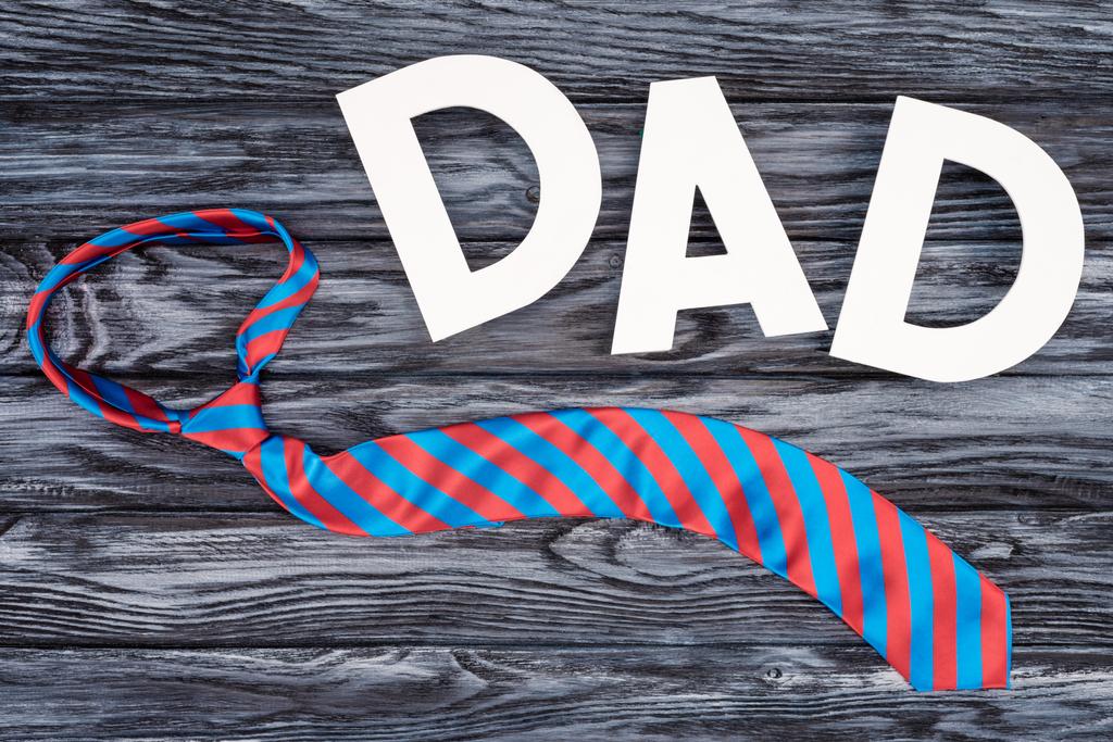 вид на вершину галстука с надписью DAD на сером деревянном столе, концепция Дня отца
 - Фото, изображение