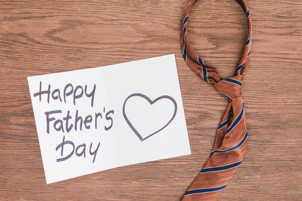 tie met Happy vaders dag wenskaart op houten oppervlak (bovenaanzicht) - Foto, afbeelding