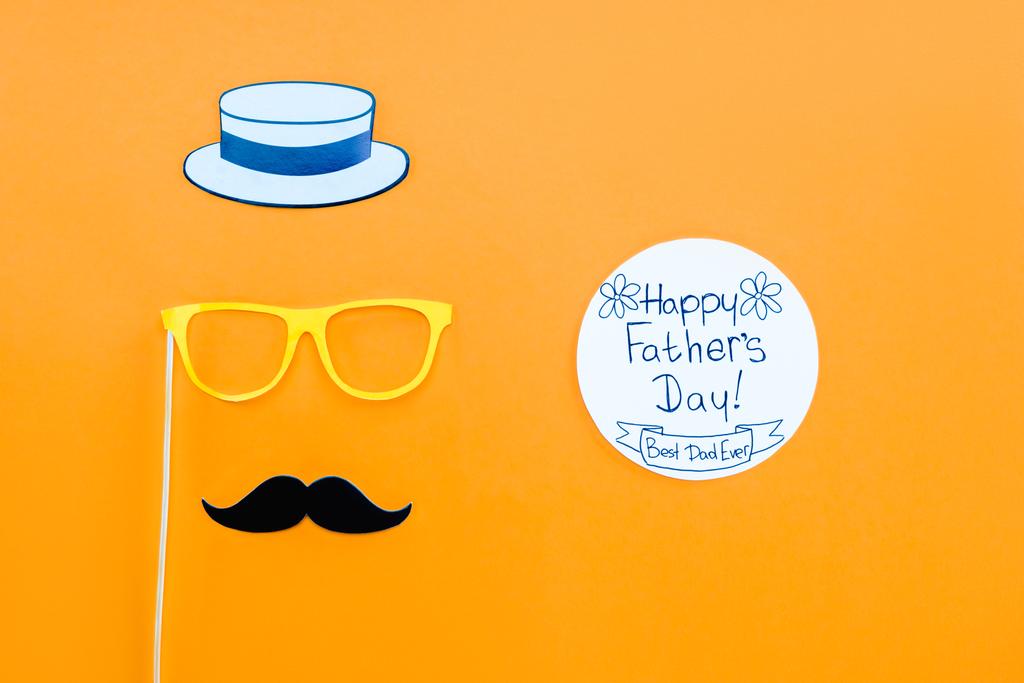 Draufsicht auf Herrengesicht mit Glückwunschkarte zum Vatertag auf gelber Fläche - Foto, Bild
