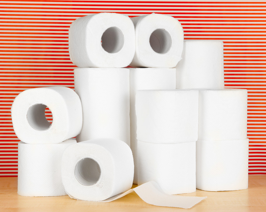 Rolos de papel higiênico sobre fundo vermelho listrado
 - Foto, Imagem