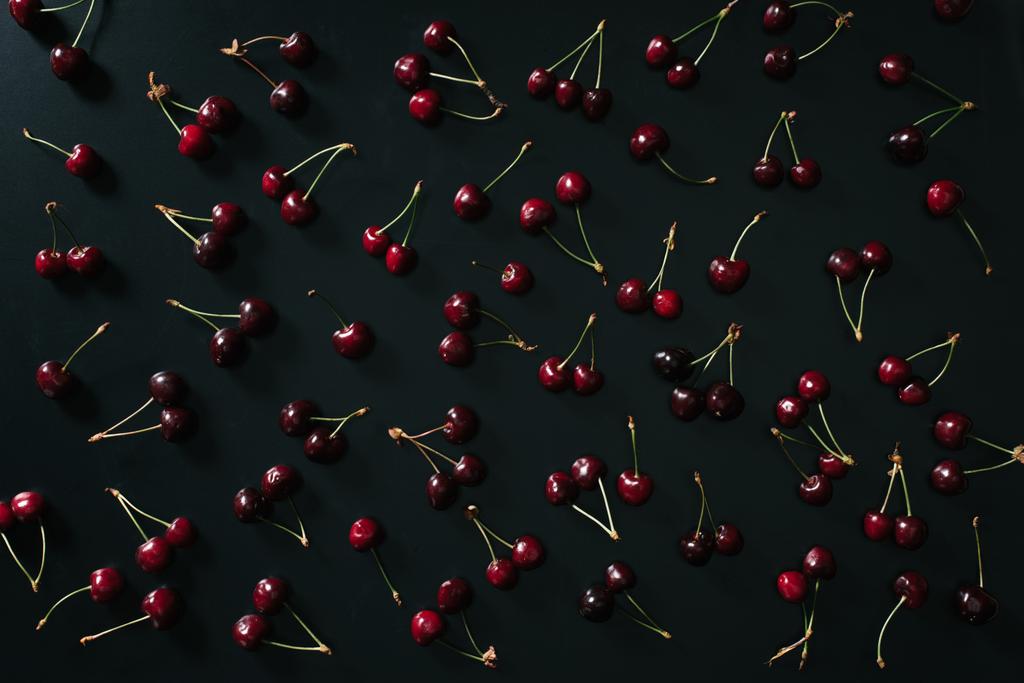 vista superior de cerejas vermelhas maduras doces no fundo preto
  - Foto, Imagem