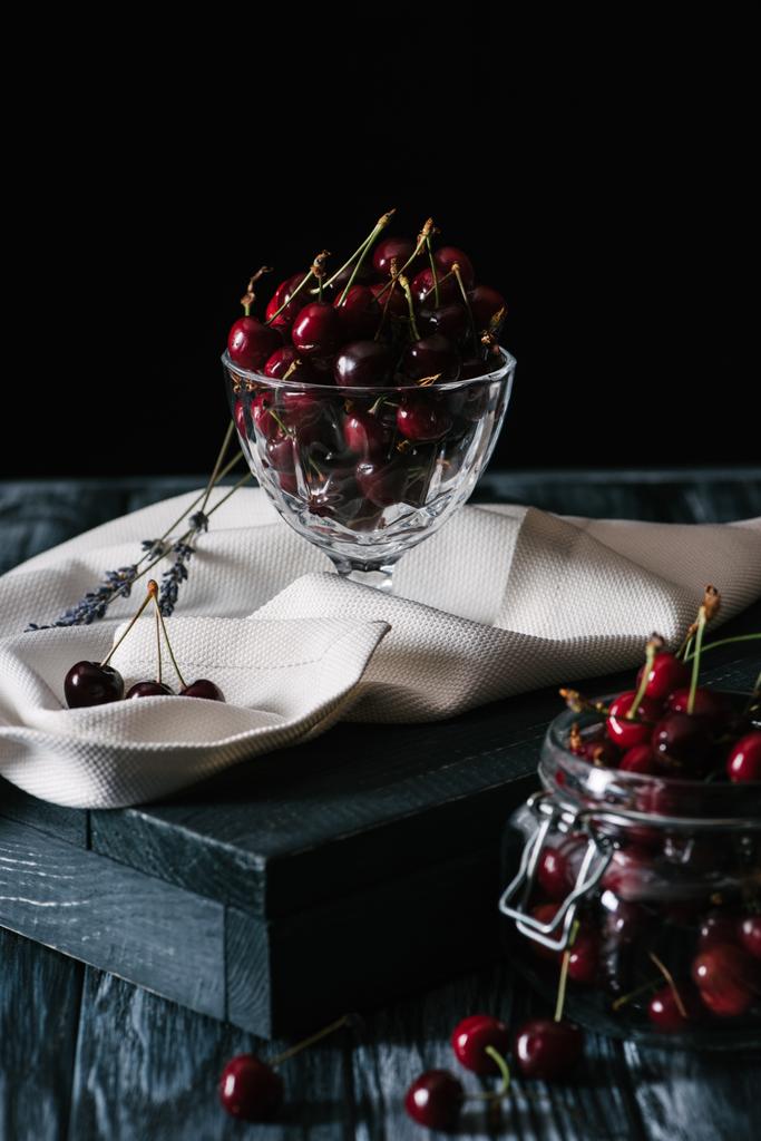 vista de cerca de cerezas dulces frescas maduras en utensilios de vidrio sobre mesa de madera
 - Foto, imagen