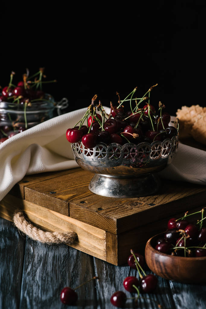 close-up view of sweet organic cherries in vintage bowl on wooden table  - Photo, Image