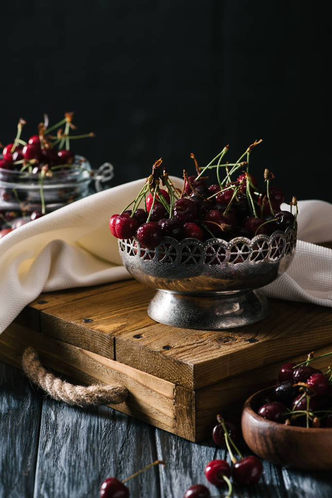 close-up view of ripe fresh cherries in vintage bowl on wooden table  - Photo, Image