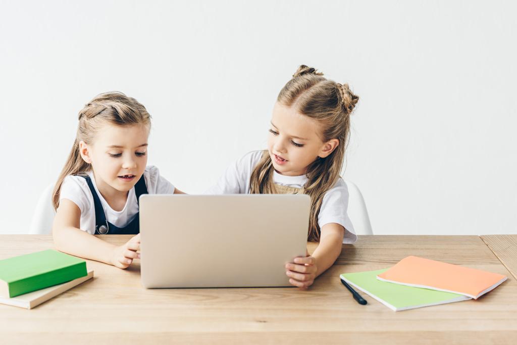 adorables petites écolières utilisant un ordinateur portable pour étudier isolé sur blanc
 - Photo, image