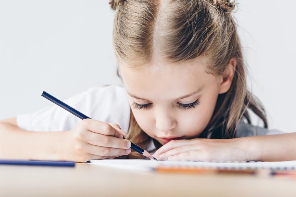 крупним планом знімок фокусованої маленької школярки з кольоровими олівцями ізольовані на білому
 - Фото, зображення