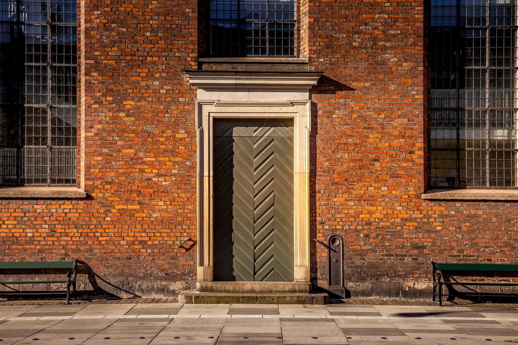 pustych ławek i budynek z dużymi oknami i zamknięte drzwi na ulicy w Kopenhadze, Dania - Zdjęcie, obraz