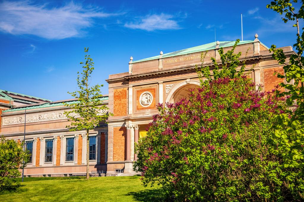 beautiful blooming lilacs and green lawn near old building in copenhagen, denmark - Photo, Image