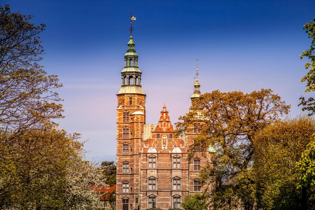 живописный вид на красивый исторический дворец между деревьями в Копенгагене, плотность
 - Фото, изображение