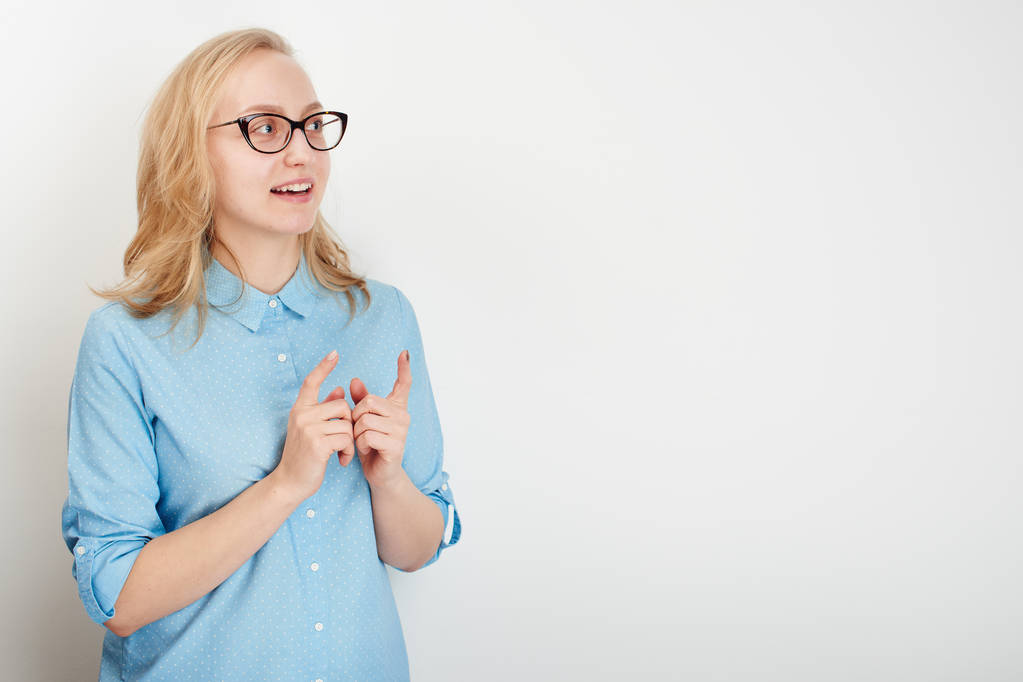 femme surprise en chemise bleue pointant les doigts de côté isolé sur fond blanc studio
 - Photo, image
