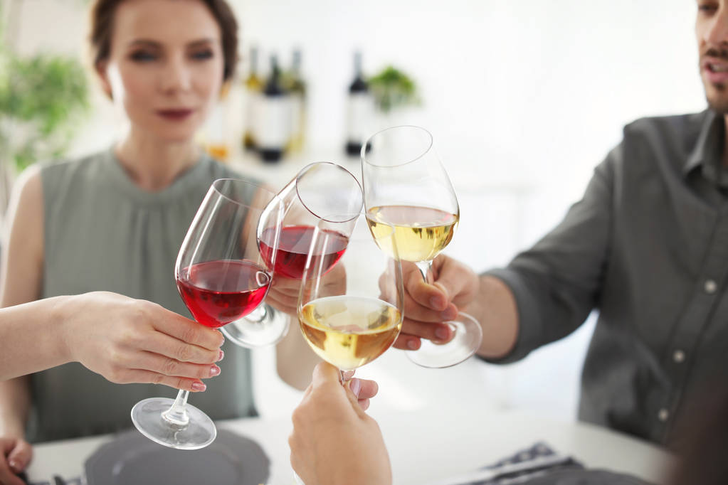 Молодые люди за столом с бокалами вкусного вина
 - Фото, изображение