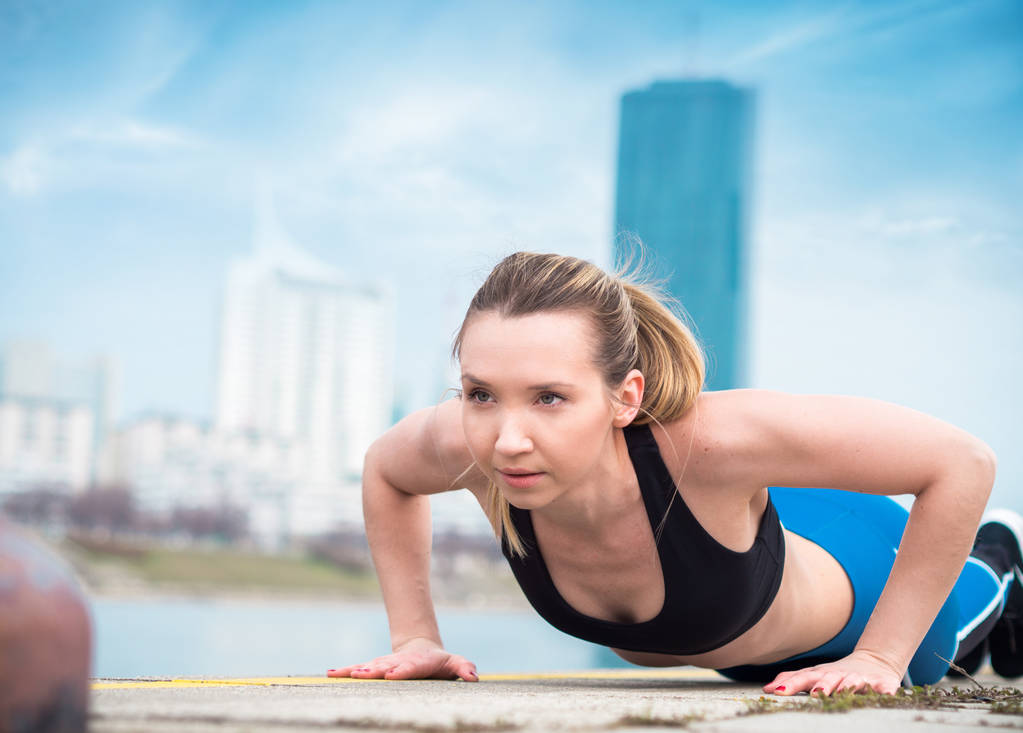 Γυμναστήριο νεαρή γυναίκα κάνει push ups, προπόνησης για γυναίκες - Φωτογραφία, εικόνα