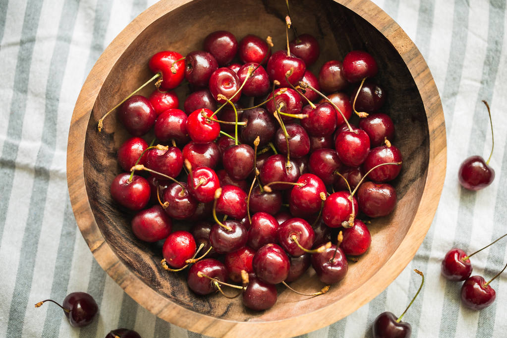 cherries in a wooden bowl on table - Photo, Image