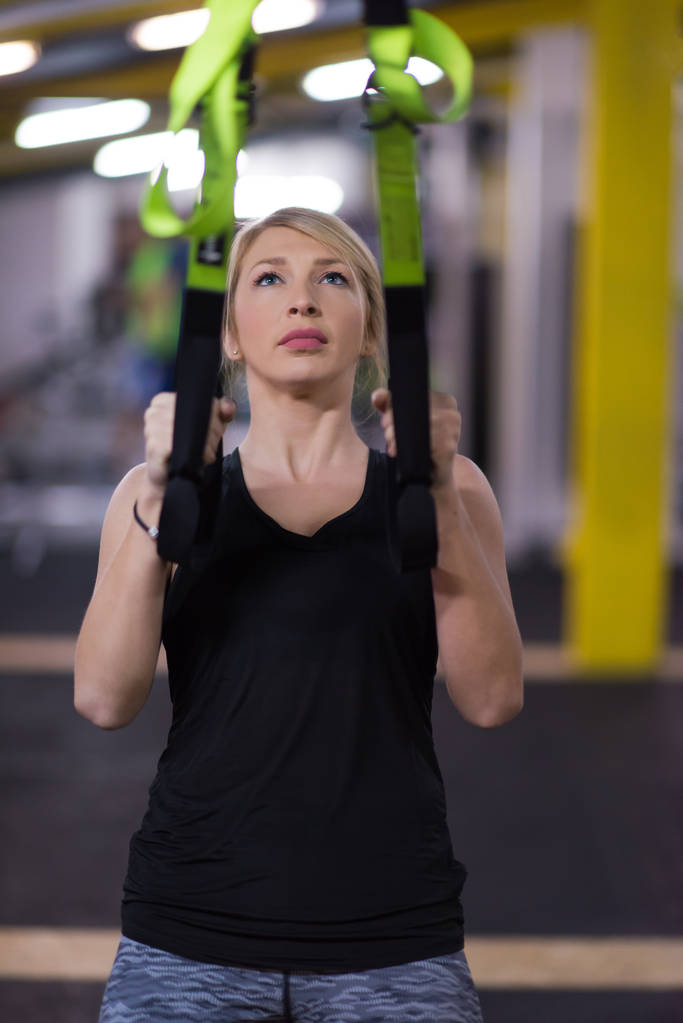 Kobieta młodego sportowca pracy pull up z gimnastyczne na siłowni fitness krzyż - Zdjęcie, obraz