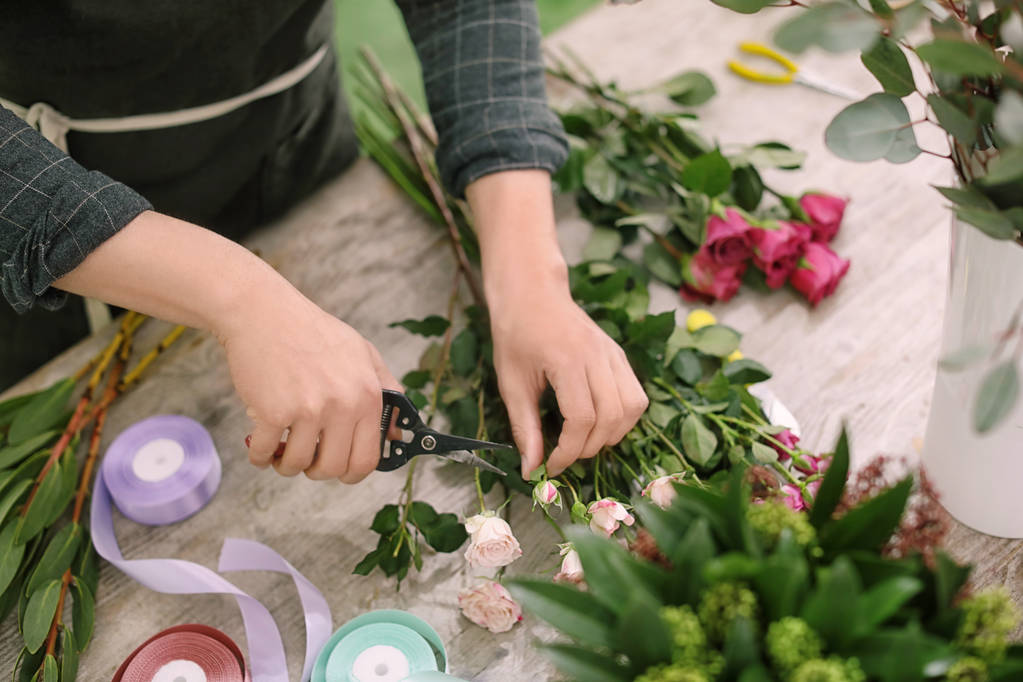 Mannelijke bloemist maken prachtige boeket in bloemenwinkel, close-up - Foto, afbeelding