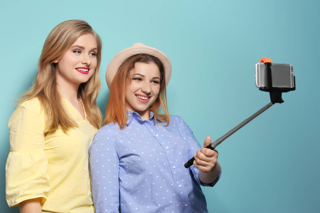 Vonzó fiatal nő vesz selfie, a háttér színét - Fotó, kép