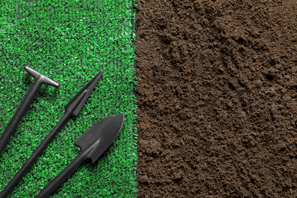 Tasainen lay koostumus puutarhanhoito työkaluja ja tekonurmella maaperään
 - Valokuva, kuva