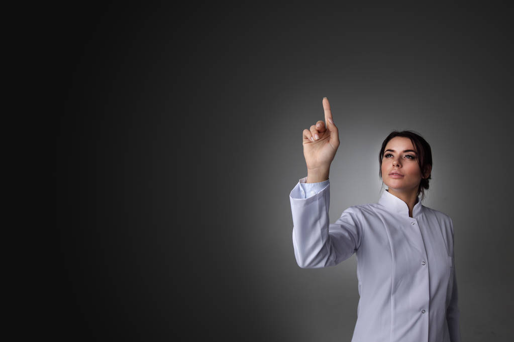Female scientist or doctor pointing to futuristic display - Photo, Image