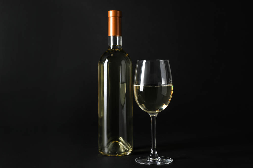 Butelki i drogie wino białe na ciemnym tle - Zdjęcie, obraz