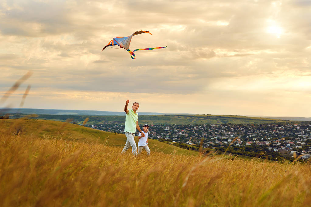 Padre e hijo jugando con una cometa en la naturaleza en el verano. Día de los padres
. - Foto, imagen