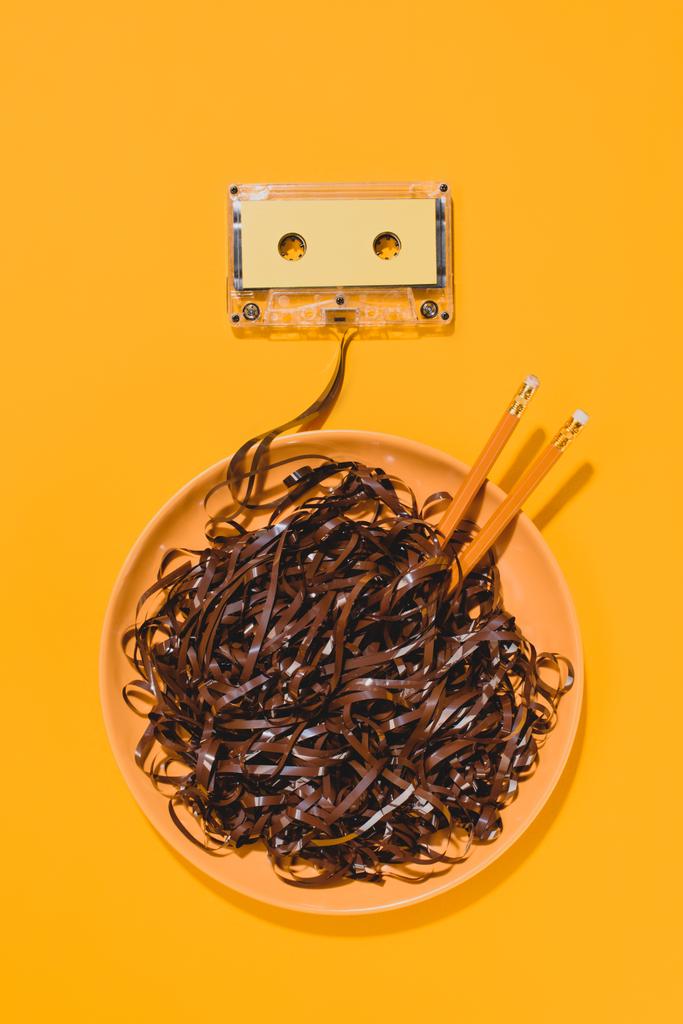 flat lay with retro audio cassette and bowl with pencils and tape isolated on yellow - Photo, Image