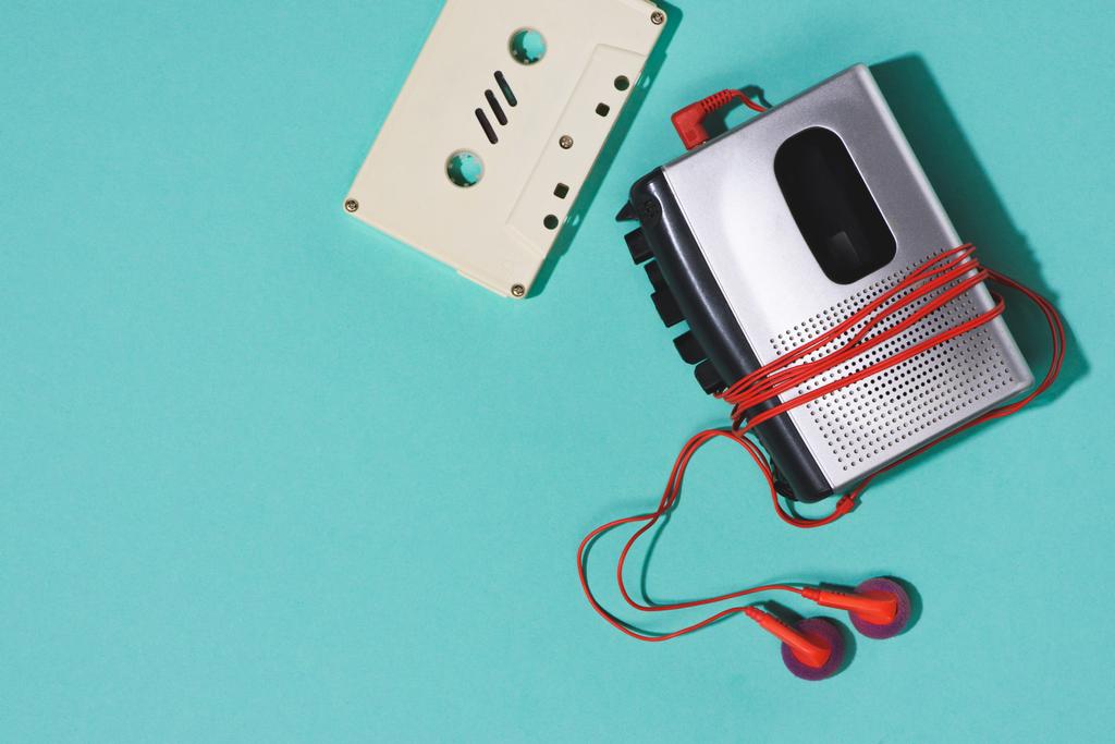 vlakke leggen met retro audiocassette, cassettespeler en oortelefoons geïsoleerd op blauw - Foto, afbeelding