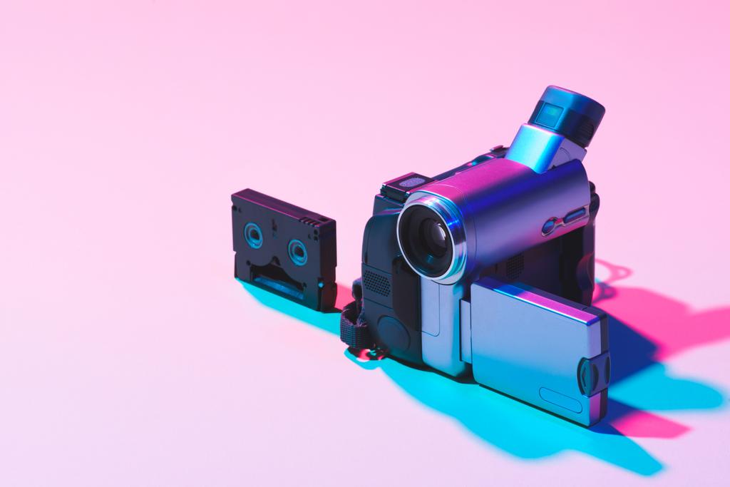 крупним планом вид відеокасети і цифрової відеокамери на рожевому фоні
 - Фото, зображення