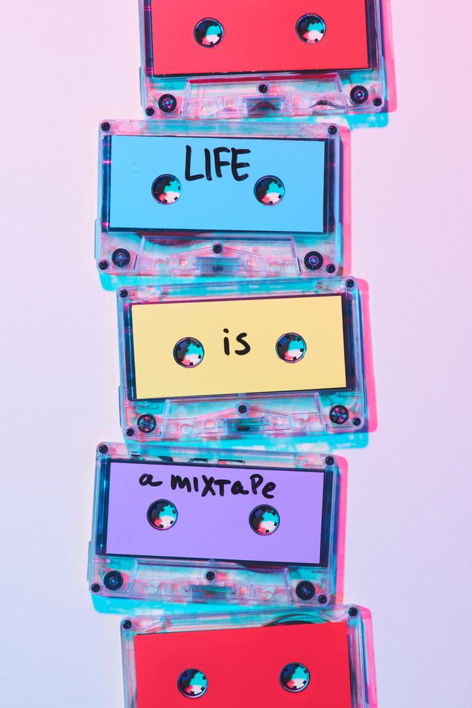 top view of arranged colorful audio cassettes with life is a mixtape inscription on purple background - Photo, Image