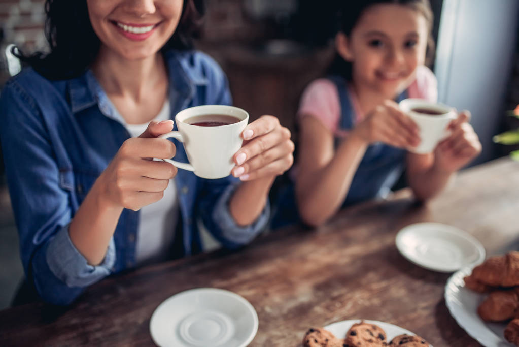 cropped shot of mother and daughter drinking tea together in the kitchen - Photo, Image