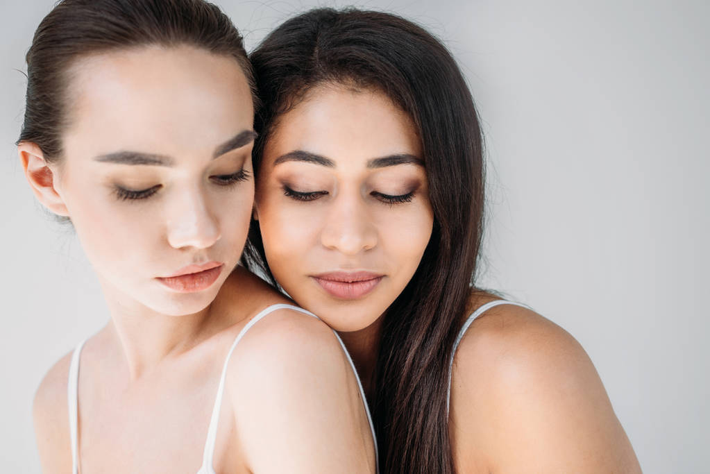 retrato de duas mulheres multiculturais atraentes posando isolado em fundo cinza
  - Foto, Imagem