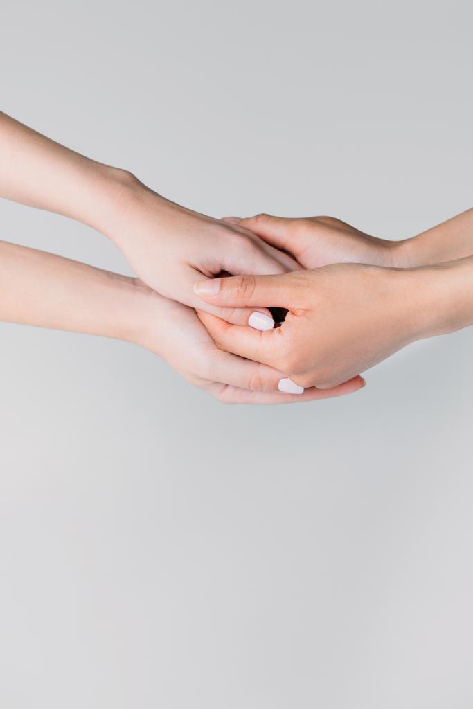 visão parcial de meninas de mãos dadas, isolado em cinza
 - Foto, Imagem