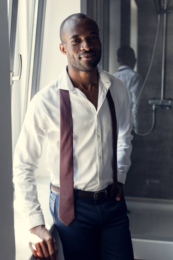 beau jeune homme d'affaires en chemise blanche avec cravate suspendue sur les épaules à la salle de bain
 - Photo, image