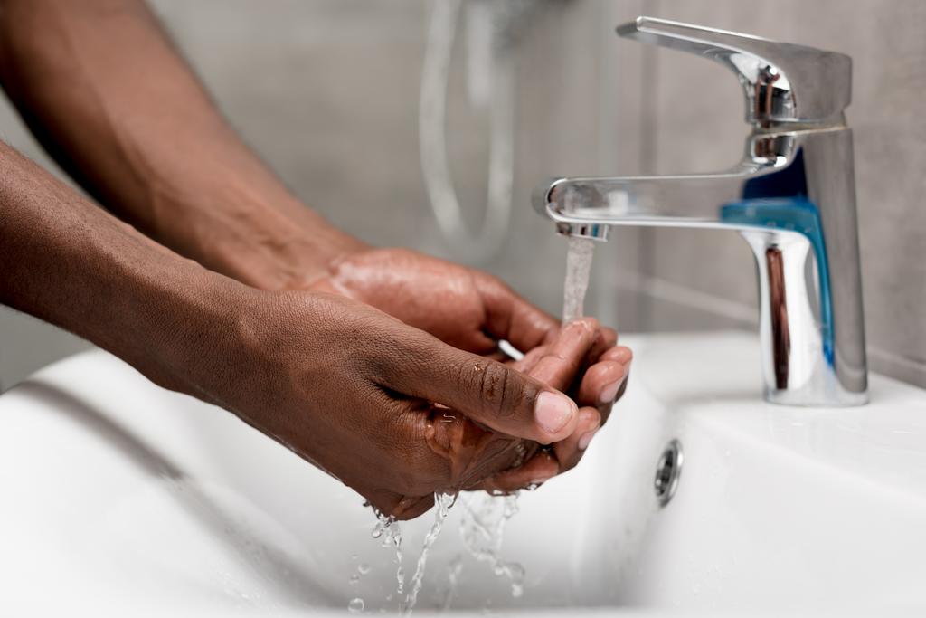 primo piano vista parziale di uomo africano americano lavaggio in bagno
    - Foto, immagini
