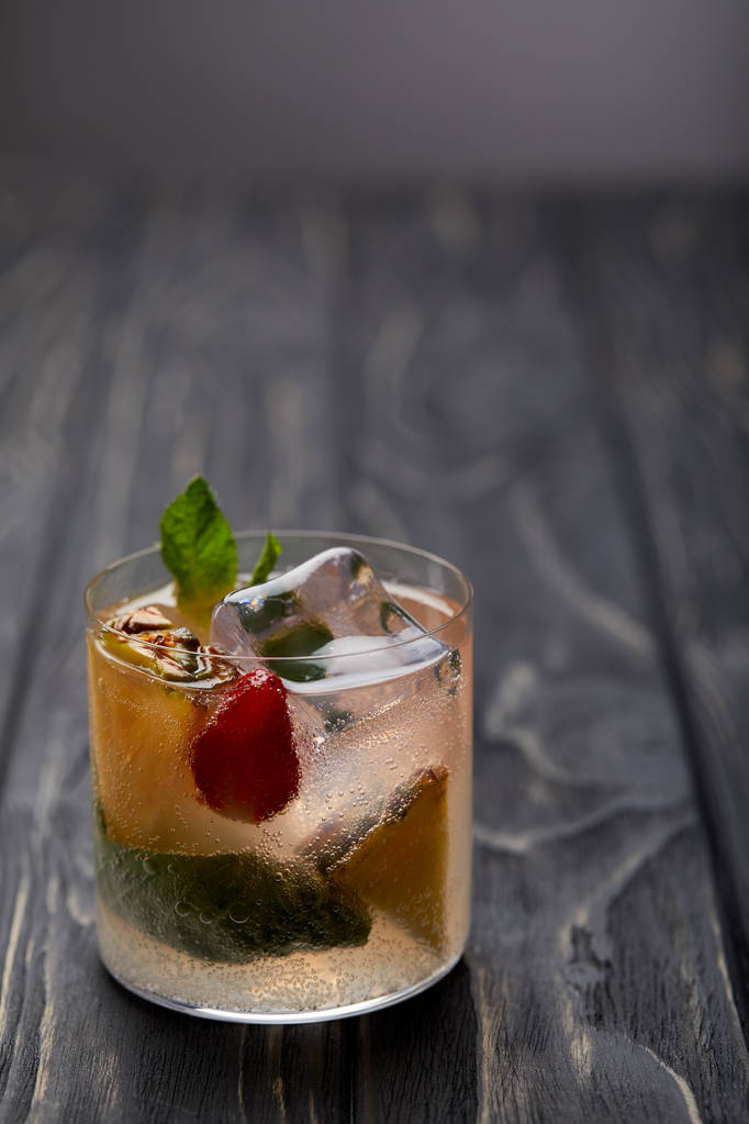 Glas Limonade mit Eiswürfeln, Minzblättern, Ananasstücken und Erdbeere - Foto, Bild