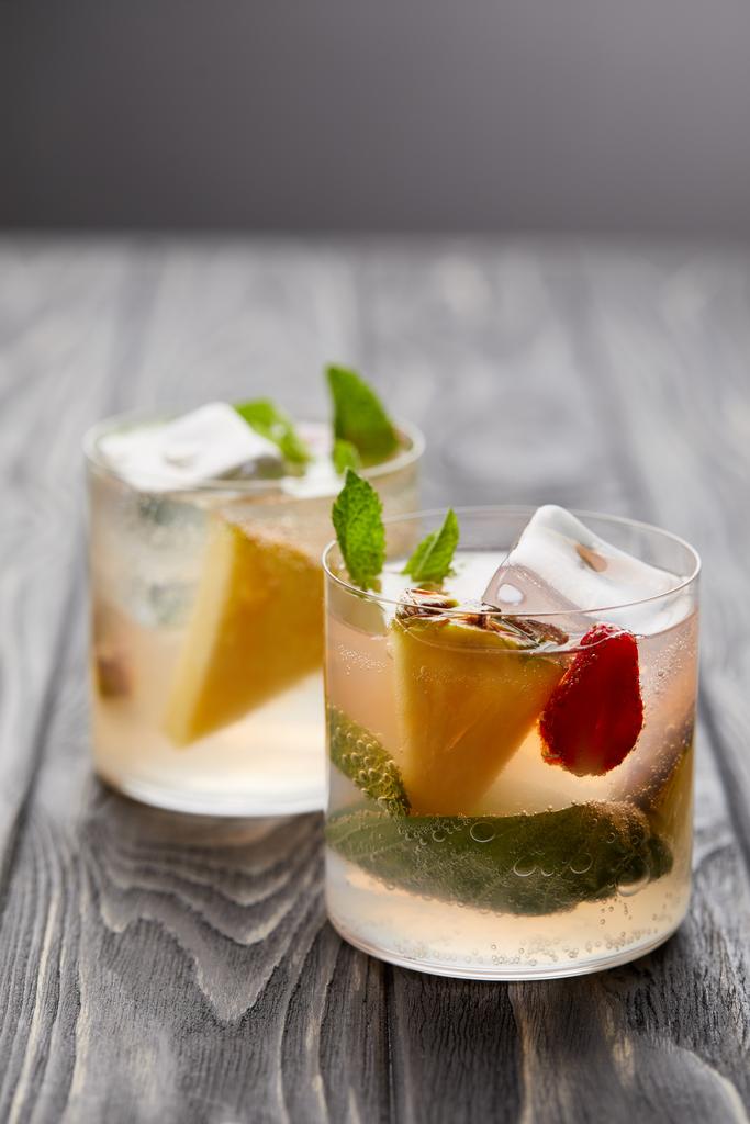 dos vasos de limonada con cubitos de hielo, hojas de menta, trozos de piña y fresa
 - Foto, Imagen
