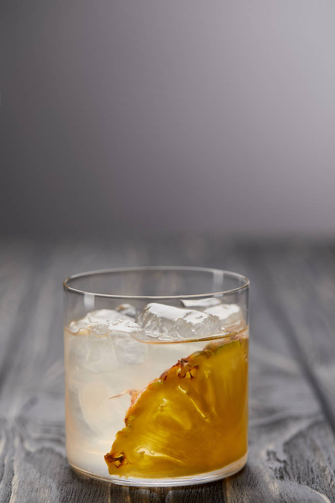 limonádé, ananász darab, és a jég kocka szürke fából készült asztal üveg - Fotó, kép