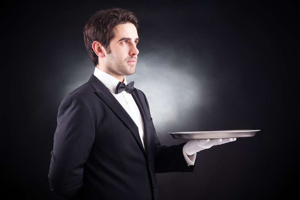 Ritratto di un giovane cameriere con un piatto vuoto su dorso nero
 - Foto, immagini