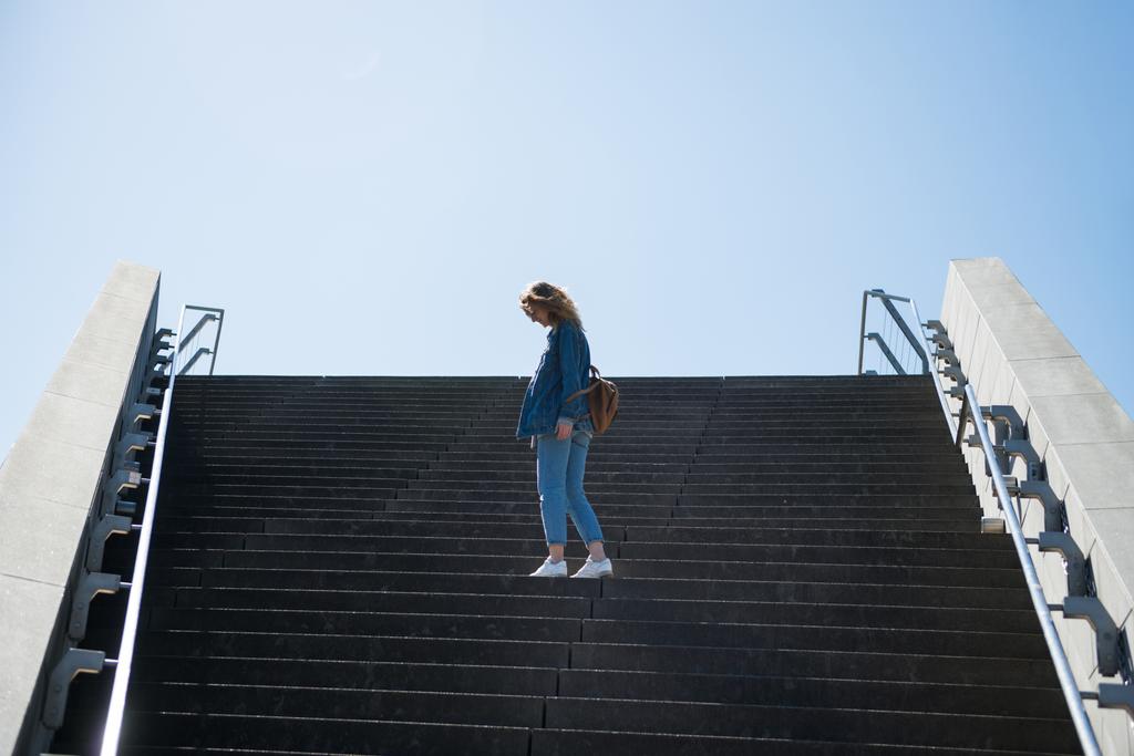side view of woman standing on steps with blue sky on background in copenhagen, denmark - Photo, Image