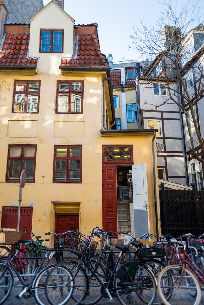fietsen geparkeerd in de buurt van huis op straat in Kopenhagen, Denemarken  - Foto, afbeelding