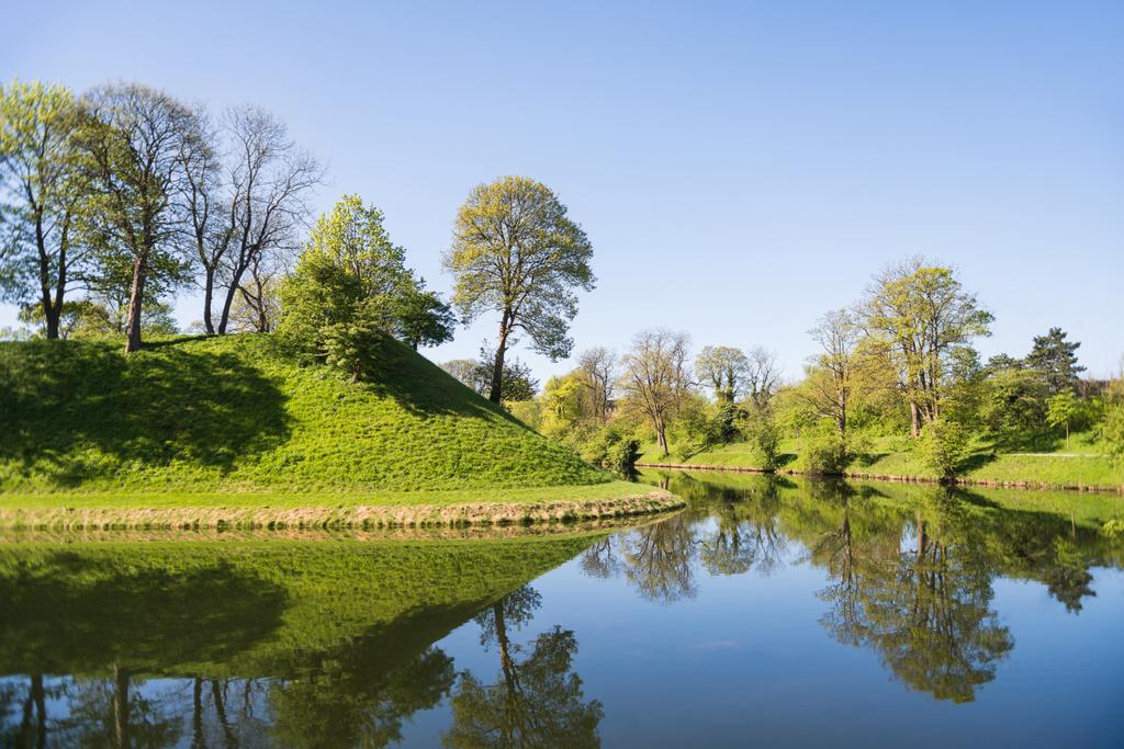 belas colinas verdes, árvores e arbustos refletidos na água, copenhagen, denmark
 - Foto, Imagem