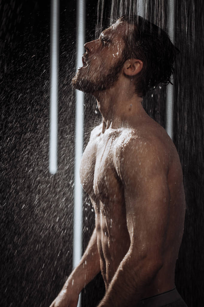 シャワーをしながらリラックスした裸の男 - 写真・画像