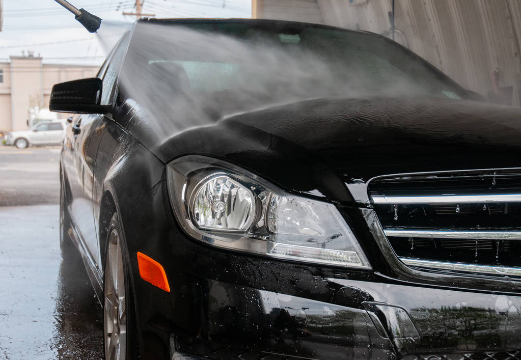 Car washing. Cleaning car using high pressure water. - Photo, Image