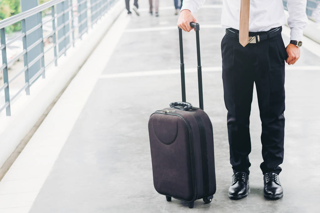 Επιχειρηματίας κρατώντας την τσάντα τρόλεϊ ανεβαίνοντας για ταξίδια - Φωτογραφία, εικόνα