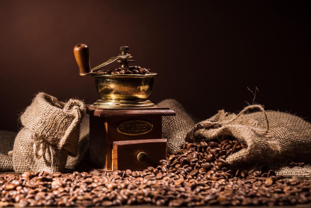 moedor de café vintage com sacos de café no fundo marrom escuro
 - Foto, Imagem