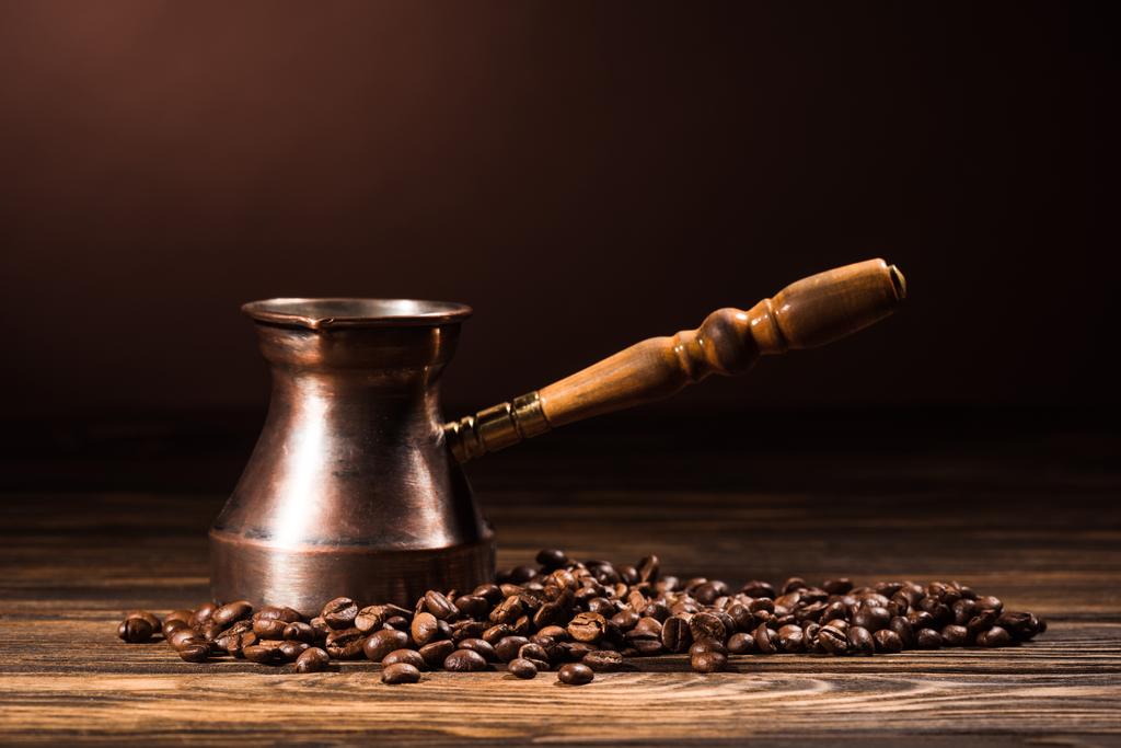 close-up shot of cezve with coffee beans on rustic wooden table - Photo, Image