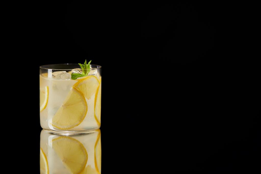 único copo de limonada fresca na superfície reflexiva isolada em preto
 - Foto, Imagem